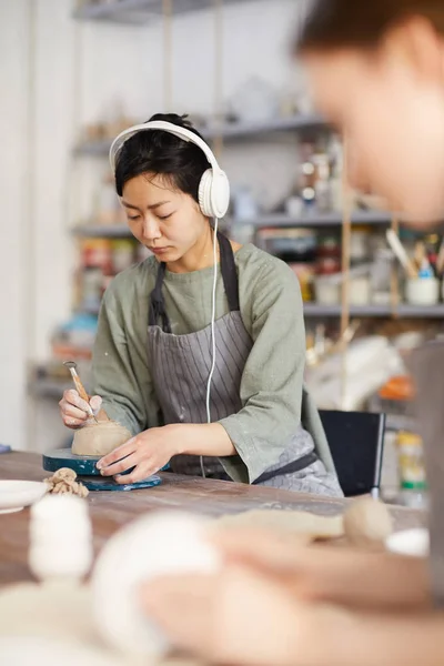 Allvarlig Ung Asiatisk Kvinna Hörlurar Stående Vid Skrivbordet Och Lyssna — Stockfoto