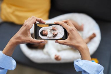 Bilinemez siyah annenin görünümü üzerinde Koza güzel bebek çocuk fotoğraf modern smartphone kullanarak
