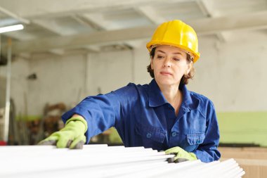 Metal üretim fabrikasında çalışan hardhat giyen yetişkin kadının bel kadar portresi, kopya alanı