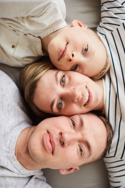 Mutlu güzel genç aile yatakta yatarken ve birlikte kamera için poz, insan yüzleri kavramı