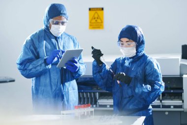 Laboratuvarda araştırma yaparken kan örnekleri ile çalışan biyolojik tehlike giysi ve maskeler ciddi konsantre çok ırklı klinik bilim adamları