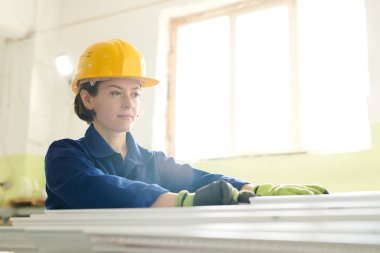 Güneş ışığında bitkide çalışan hardhat giyen gülümseyen genç kadının portresi, kopya alanı