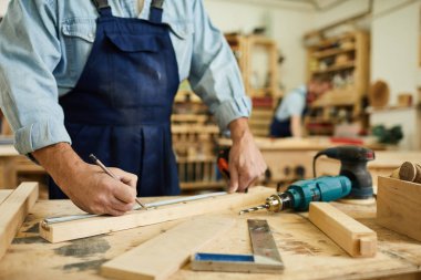 Atölyede masada duran ahşap ile çalışan olgun marangoz yakın çekim, kopyalama alanı