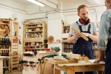 Atölyede üst düzey işçi konuşan genç marangoz Portresi, kopya alanı