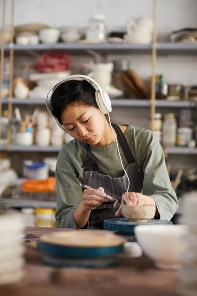 Serieux Concentré Jeune Potier Asiatique Inspiré Par Musique Assis Bureau — Photo