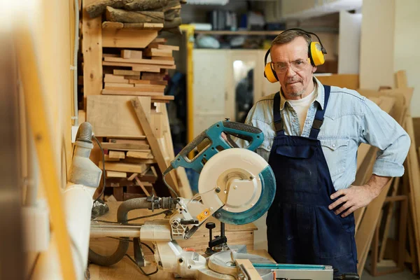 Doğrama, kopya alanı çalışırken disksaw tarafından ayakta duran kıdemli marangoz bel kadar portre