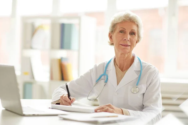 Retrato Del Médico Senior Sonriente Sentado Escritorio Oficina Mirando Cámara — Foto de Stock