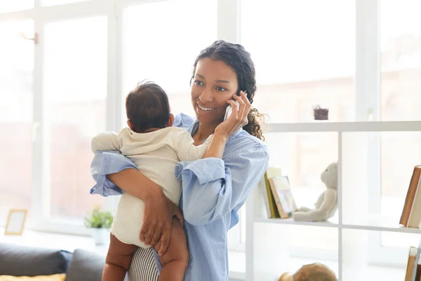 Lächelnd Steht Die Schöne Junge Schwarze Mutter Wohnzimmer Und Telefoniert — Stockfoto