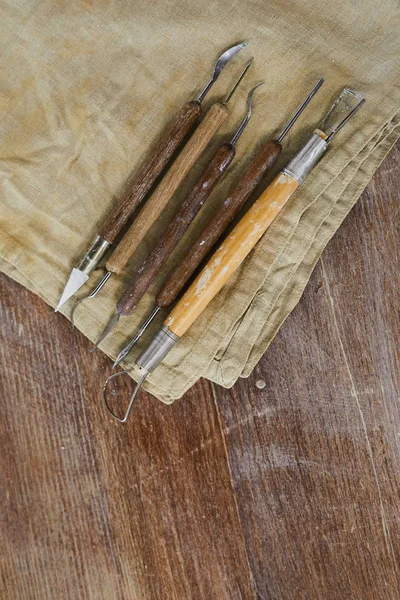 各种雕刻工具的特写 用于在木桌上放置的脏餐巾上进行粘土建模 — 图库照片
