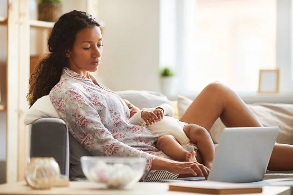 Content Pensive Drukke Jonge Zwarte Moeder Katoen Homewear Zittend Sofa — Stockfoto