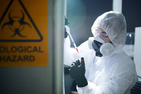 集中的实验室科学家在保护工作服 橡胶手套 护目镜和呼吸器遵守安全 同时工作与受感染的物质 — 图库照片