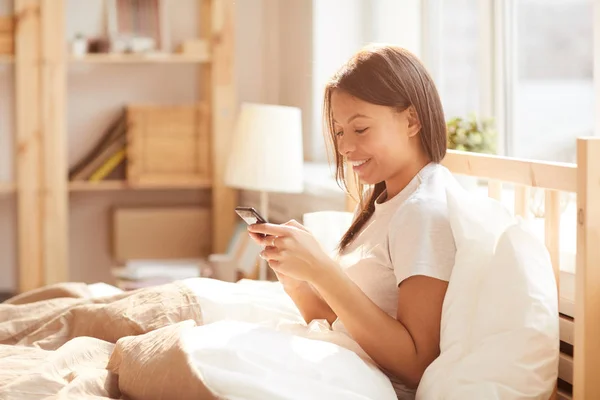 Portrait Beautiful Mixed Race Woman Using Smartphone Sitting Bed Lit — Stock Photo, Image