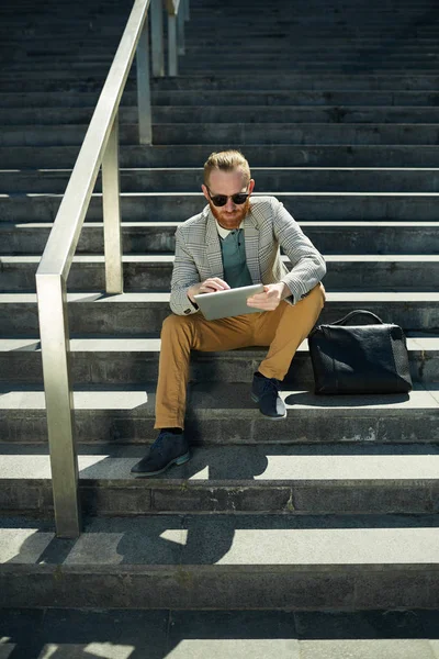 Serieuze Geconcentreerde Hipster Zakenman Met Rode Baard Zittend Trap Buitenshuis — Stockfoto