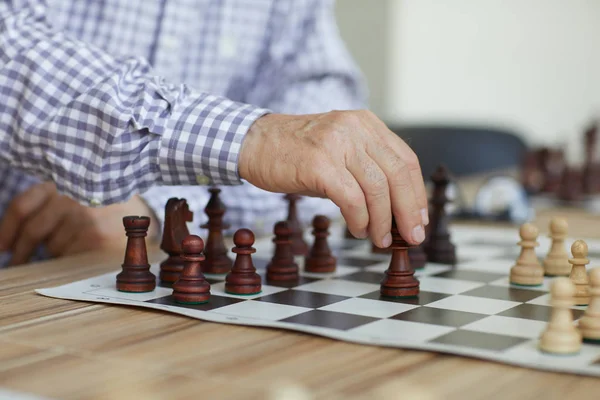 Yoğun oyun sırasında kararlı satranç hareket yapma eski profesyonel grandmaster tabaklanmış buruşuk el