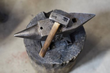 Atölyede çelik örs üzerine yerleştirilen metali şekillendirmek için çekiç görünümüdoğrudan yukarıda, smithy arka plan