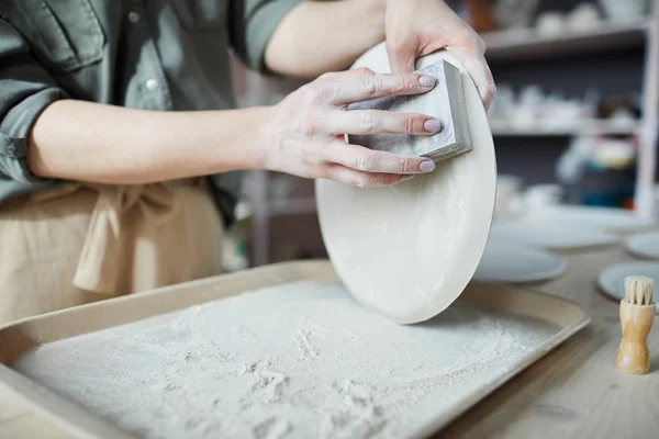 Zbliżenie Nierozpoznawalnej Młodej Kobiety Szlifowanie Ręcznie Ceramicznej Miski Warsztacie Garncarskiej — Zdjęcie stockowe
