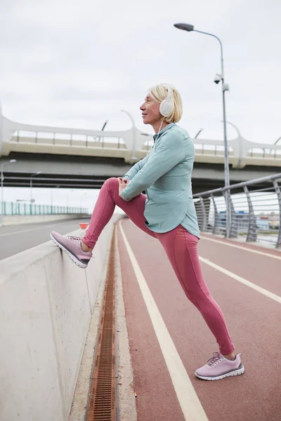 Mulher Madura Ativa Leggins Windbreaker Fazendo Exercício Para Pernas Esticar — Fotografia de Stock