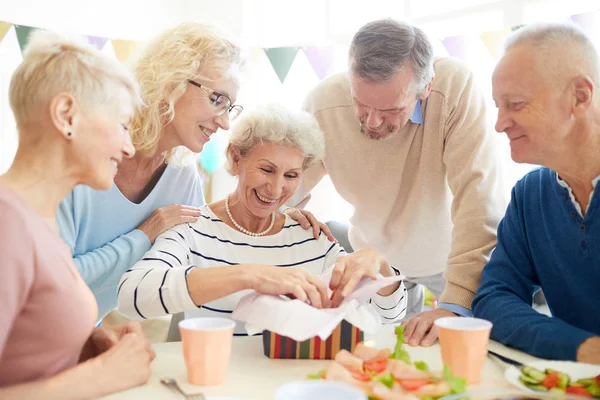 Jolly Positive Senior Woman Curly Hair Sitting Table Opening Gift — Stock Photo, Image