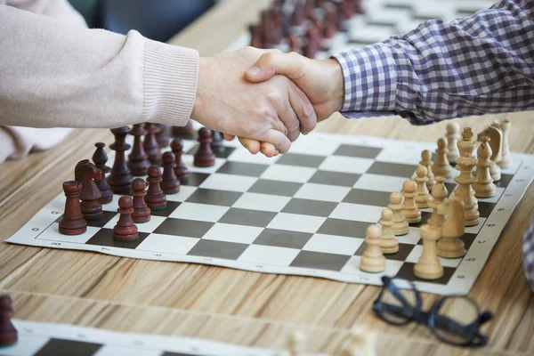 Två Man Skakar Hand Över Bordet Schackbräde Och Glasögon Innan — Stockfoto