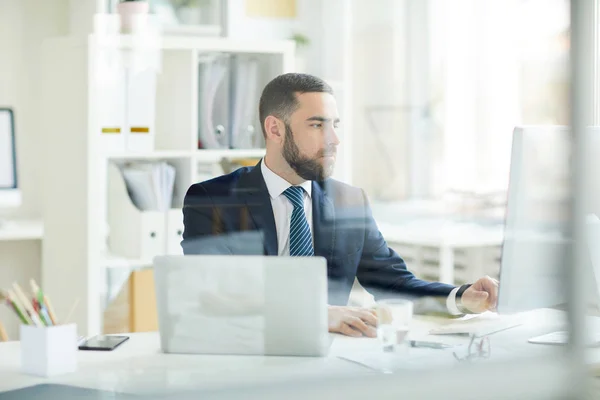 Joven Analista Negocios Barbudo Enfocado Serio Traje Sentado Escritorio Haciendo — Foto de Stock