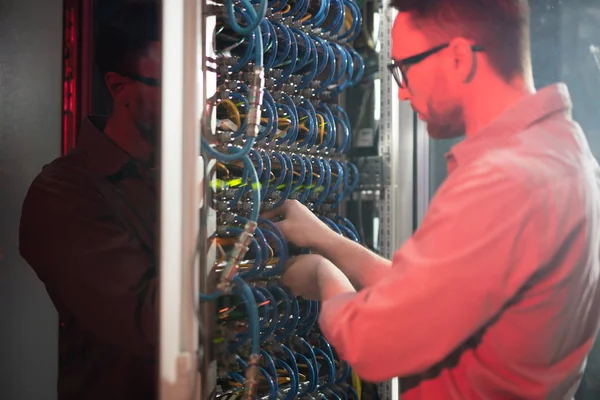 Especialista Jovem Ocupado Sério Óculos Por Mainframe Poderoso Examinando Cabos — Fotografia de Stock