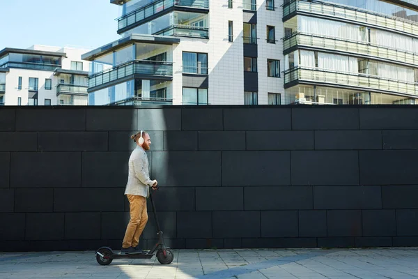 Zijaanzicht Van Inhoud Sportieve Hipster Zakenman Hoofdtelefoon Rijden Kick Scooter — Stockfoto