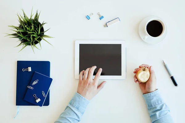 Directly View Unrecognizable Manager Eating Apple Using Tablet While Filling — Stock Photo, Image