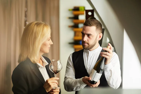 Warm Toned Portrait Sommelier Showing Wine Bottle Woman Restaurant Copy — Stock Photo, Image