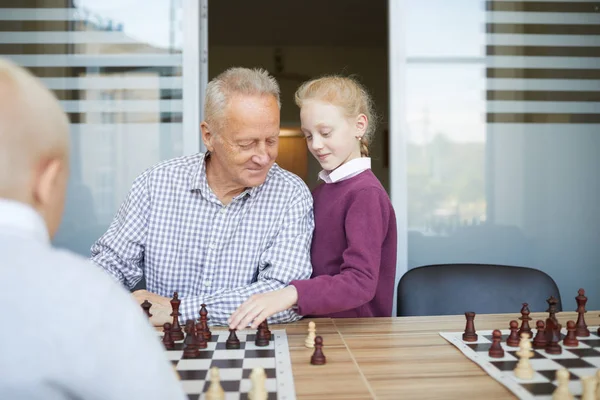 Small Girl Red Braided Hair Helping Her Grandfather Win Chess — Stock Photo, Image