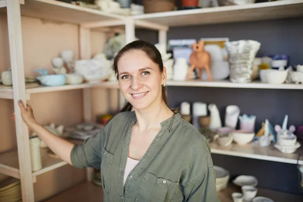 Portret Van Glimlachend Vrouwelijke Artisan Poseren Aardewerk Studio Tegen Planken — Stockfoto