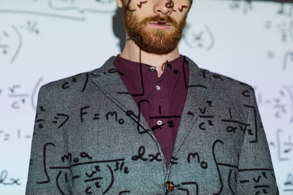 Bearded man in gray jacket standing against projection screen displaying mathematical calculations, copy space