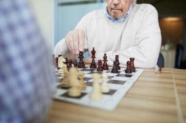Kontrol gömlek rakibi ile satranç oynarken gri sakallı yaşlı deneyimli profesyonel grandmaster