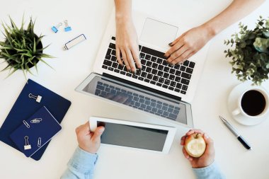 Birbirinin karşısında oturan ve iş ve iş, birlikte çalışma alanı için modern cihazlar kullanarak tanınmayan serbest yukarıda görünümü