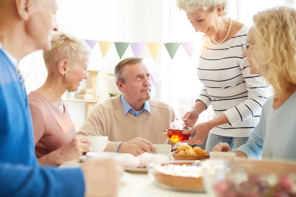 Lachende Gastvrije Dame Met Ketting Staan Aan Tafel Gieten Thee — Stockfoto