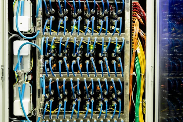 Background image of blue cables of network panel connecting supercomputer in database center