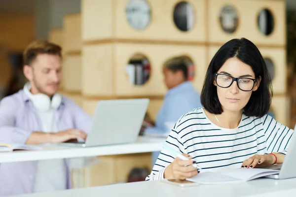 Giovane Donna Concentrata Occhiali Vista Seduta Tavola Con Computer Portatile — Foto Stock