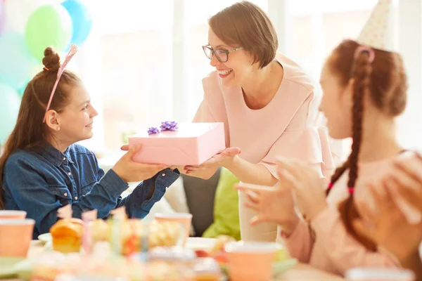 友人との誕生日パーティー中にママから贈り物を受け取る幸せな女の子の肖像画 コピースペース — ストック写真