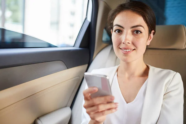 Portret Uśmiechniętej Bizneswoman Pomocą Smartfona Taksówce Patrząc Kamerę Kopiuj Przestrzeń — Zdjęcie stockowe