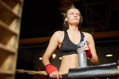 Sert kadın savaşçı içme suyu düşük açı portre ve boks halkası uygulama sırasında uzağa bakarak, kopya alanı