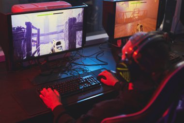 Kulaklıkta tanınmayan adamın arka dansı masada otururken ve arcade çekim oyunu oynarken
