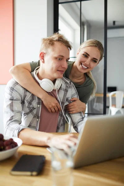 Happy Girl Embracing Her Boyfriend While Both Looking Laptop Display — Stock Photo, Image