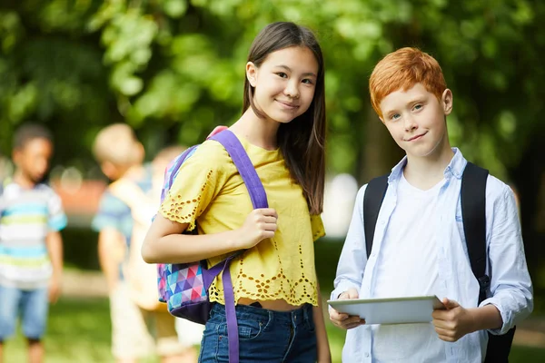 Två Leende Skolbarn Som Står Utanför Framför Skolan Och Pratar — Stockfoto