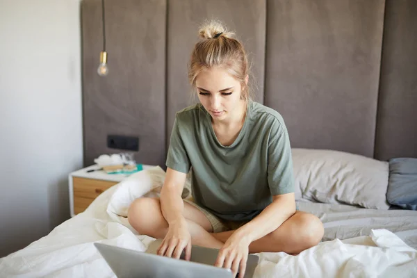 Cute Blond Dziewczyna Shirt Wpisując Patrząc Wyświetlaczu Laptopa Siedząc Łóżku — Zdjęcie stockowe