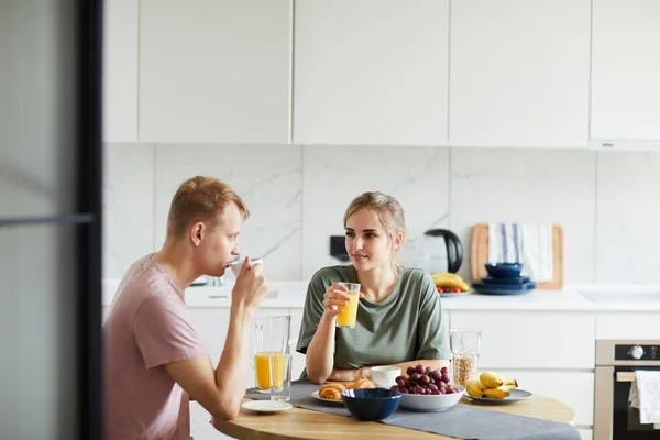 Ung Kvinna Och Hennes Man Dricker Apelsinjuice Med Frukost Morgonen — Stockfoto