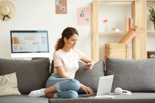 Chica Moderna Alegre Camiseta Jeans Sentado Sofá Casa Uso Tarjeta — Foto de Stock