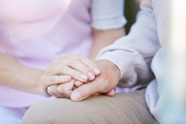 Zor zamanlarda birbirlerini destekleyen el ele tutuşan tanınmayan yetişkin çiftin yakınçekimalanı, kopya alanı