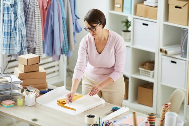 Online mağaza ofis genç işçi ambalaj önce kağıt katlanmış pullover sarma sırasında masa başında ayakta