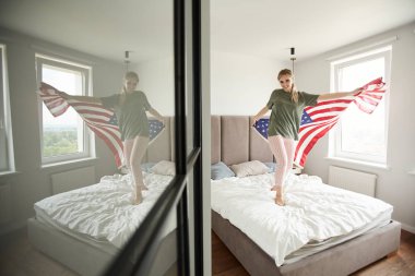 Ulusal Bağımsızlık Günü kutlayan Amerikan bayrağı ile Neşeli genç kadın vatansever