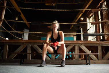 Spor kulübünde boks ringi tarafından bekleyen güçlü genç kadının tam uzunlukta portre, kopya alanı