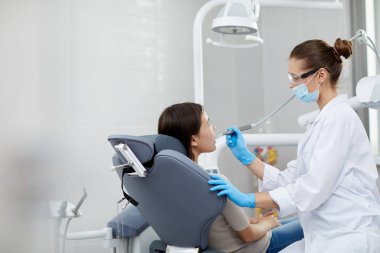Klinikte çocuk muayene kadın diş hekimi yan görünüm portresi, kopya alanı